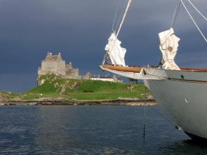 Schottland Charter: Grandiose Landschaft mit dunklen Wolken, einem Schloss, moosgrüne Hügel...